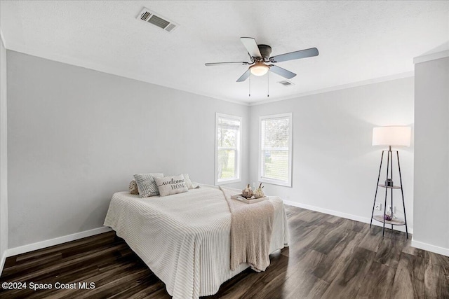 bedroom with crown molding, a textured ceiling, dark hardwood / wood-style floors, and ceiling fan