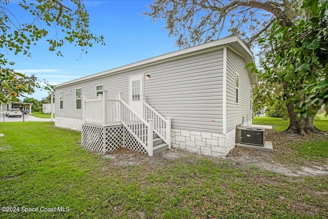 back of property featuring central AC unit, a patio, and a yard