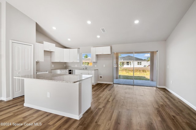 kitchen with a center island, white cabinetry, and lofted ceiling