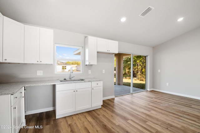 kitchen featuring light hardwood / wood-style flooring, white cabinetry, a healthy amount of sunlight, and sink