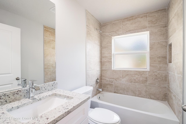 full bathroom with vanity, tiled shower / bath combo, and toilet