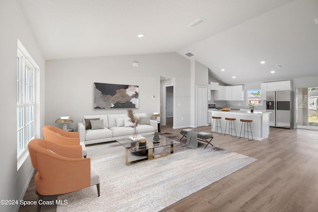 living room with light hardwood / wood-style floors and lofted ceiling