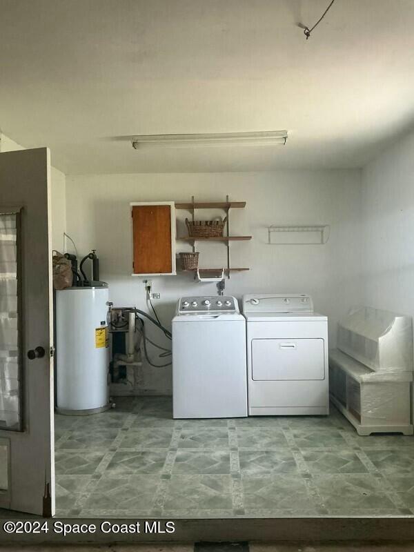 washroom with gas water heater and washer and dryer