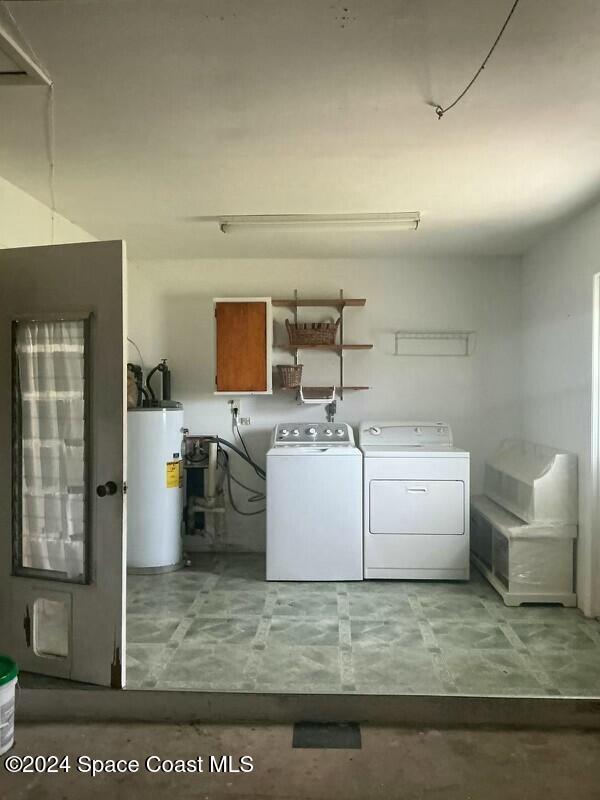 laundry area with gas water heater and independent washer and dryer