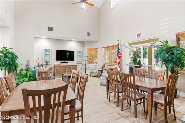 dining space with high vaulted ceiling, light wood-type flooring, and ceiling fan