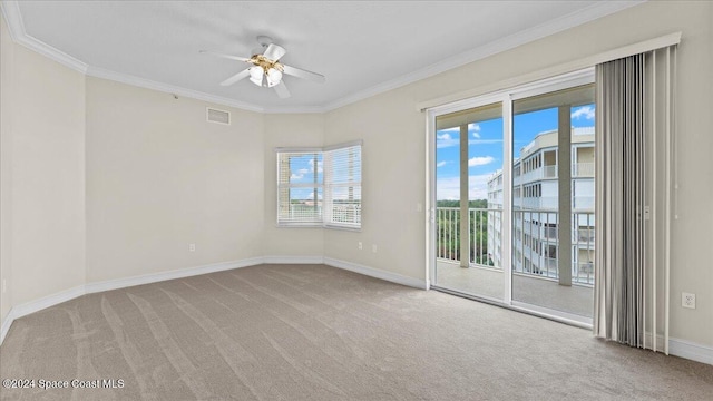 empty room with a healthy amount of sunlight, light carpet, and crown molding