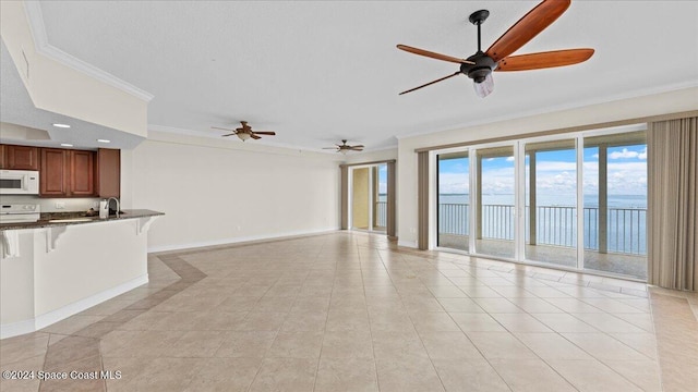 unfurnished living room with a water view, light tile patterned floors, crown molding, and ceiling fan