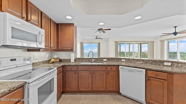 kitchen featuring white appliances, a textured ceiling, sink, and a wealth of natural light