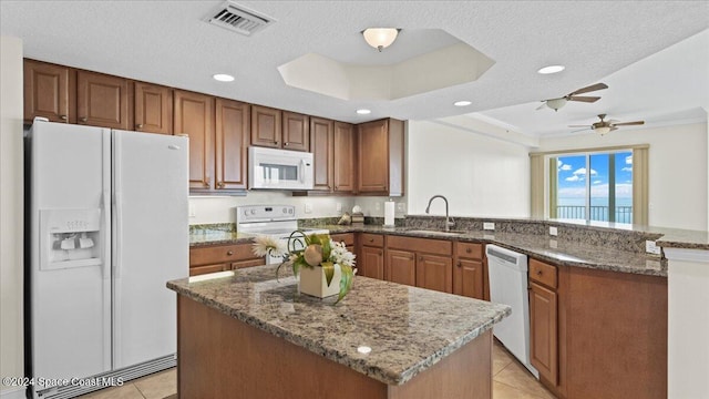 kitchen featuring light tile patterned flooring, sink, kitchen peninsula, a textured ceiling, and white appliances