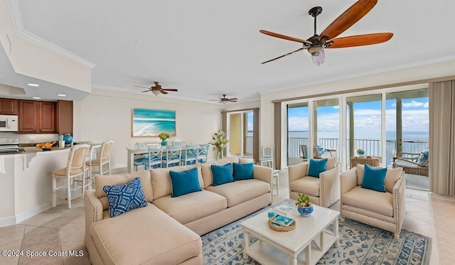 tiled living room featuring ceiling fan, a water view, and crown molding