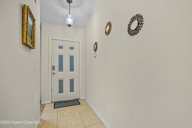 doorway featuring a textured ceiling and light tile patterned flooring