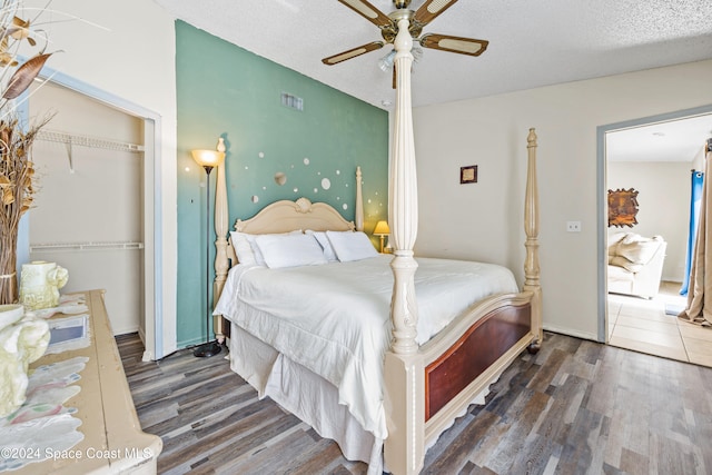 bedroom featuring a textured ceiling, dark hardwood / wood-style floors, ceiling fan, and a closet