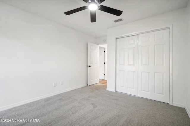 unfurnished bedroom with ceiling fan, a closet, and light colored carpet