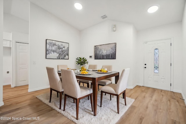 dining area featuring light hardwood / wood-style floors and vaulted ceiling