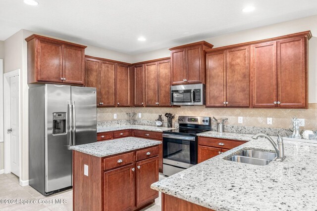 3540 Watergrass St, West Melbourne, FL 32904 - kitchen with appliances with stainless steel finishes, a sink, light stone countertops, tasteful backsplash, and a kitchen island