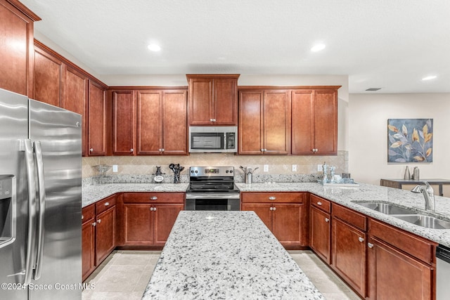 kitchen featuring tasteful backsplash, light stone counters, stainless steel appliances, light tile patterned floors, and sink