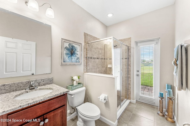 bathroom with vanity, a shower with door, tile patterned floors, and toilet