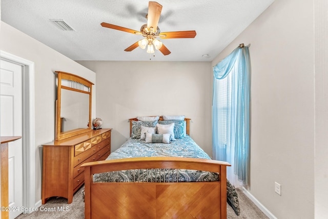 bedroom featuring ceiling fan, a textured ceiling, and light colored carpet