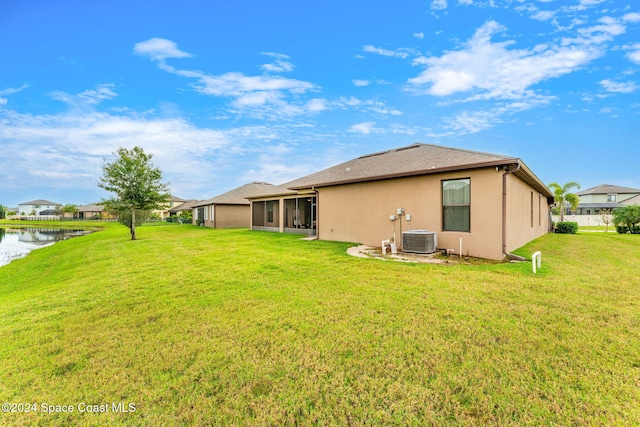 3540 Watergrass St, West Melbourne, FL 32904 - rear view of house with a sunroom, a water view, a lawn, and stucco siding