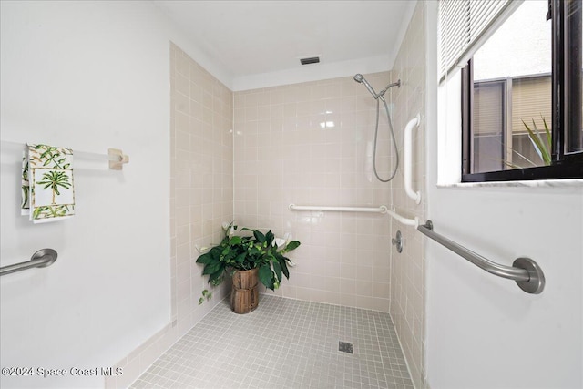 bathroom featuring tile patterned flooring and tiled shower