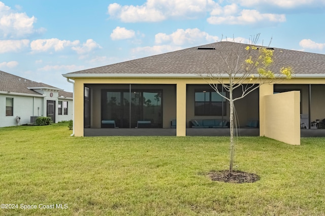 back of house featuring a sunroom and a yard