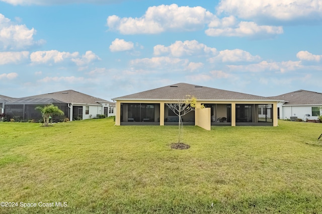 back of property featuring a lanai, a lawn, and a sunroom