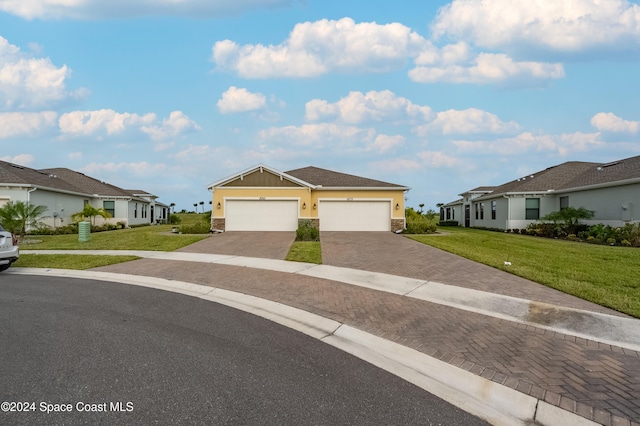 ranch-style home with a garage and a front lawn