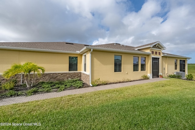 view of front of home featuring a front lawn and cooling unit