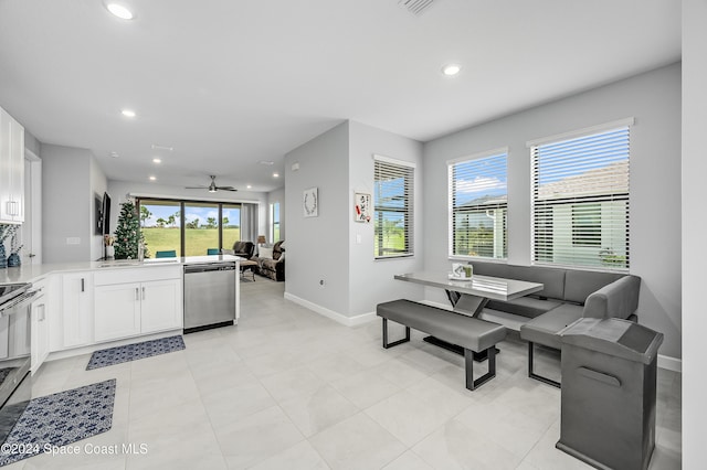 living room with sink, light tile patterned floors, and ceiling fan