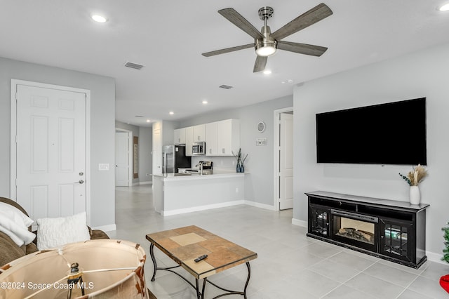 living room with light tile patterned flooring and ceiling fan