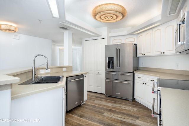 kitchen featuring white cabinetry, appliances with stainless steel finishes, dark wood-type flooring, and sink