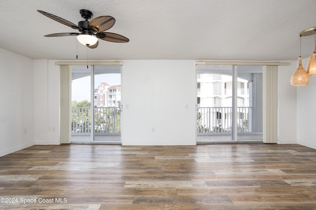 spare room featuring a textured ceiling, hardwood / wood-style flooring, and ceiling fan