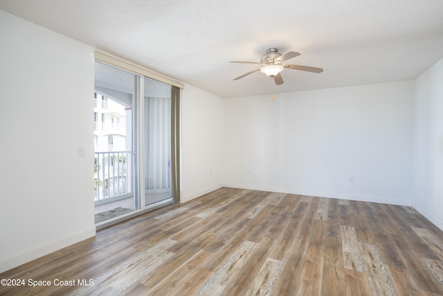 empty room with a textured ceiling, light hardwood / wood-style floors, and ceiling fan