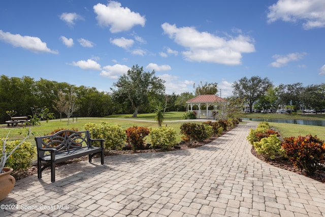 view of property's community featuring a water view, a yard, and a gazebo