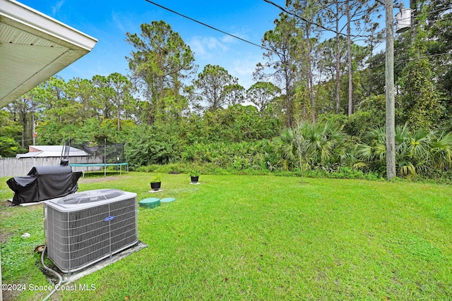 view of yard with central air condition unit and a trampoline