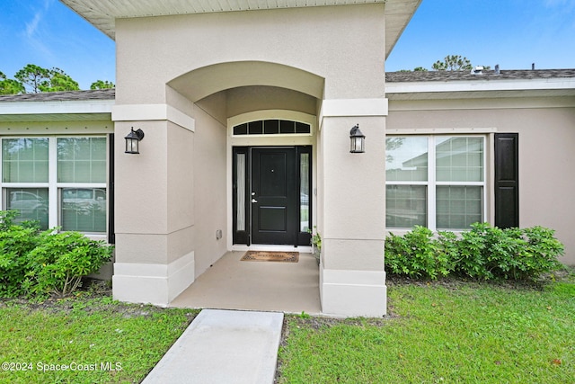 entrance to property featuring a yard