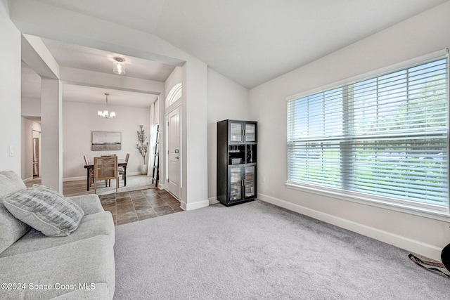 living room featuring light colored carpet, a chandelier, and lofted ceiling