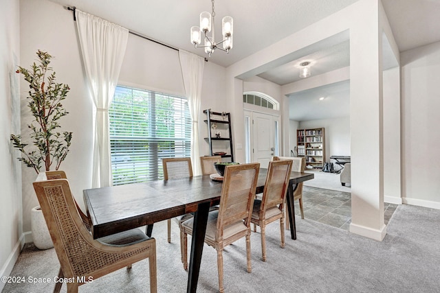 dining space with carpet and a notable chandelier