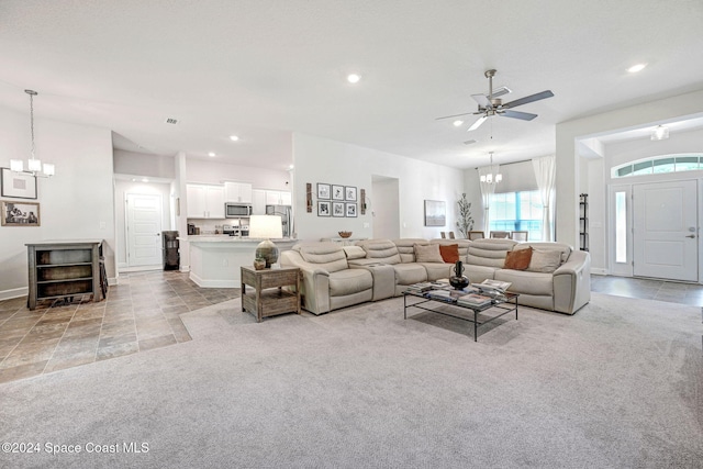 living room featuring ceiling fan with notable chandelier and light carpet