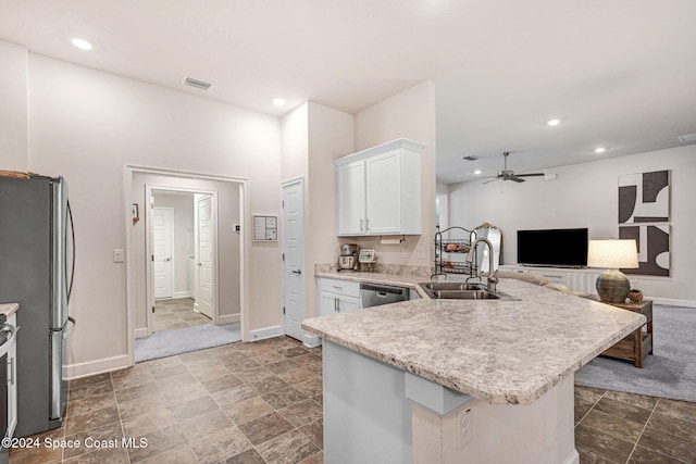 kitchen with appliances with stainless steel finishes, sink, white cabinets, kitchen peninsula, and ceiling fan