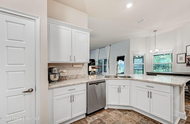 kitchen with light stone counters, white cabinets, sink, stainless steel dishwasher, and decorative light fixtures