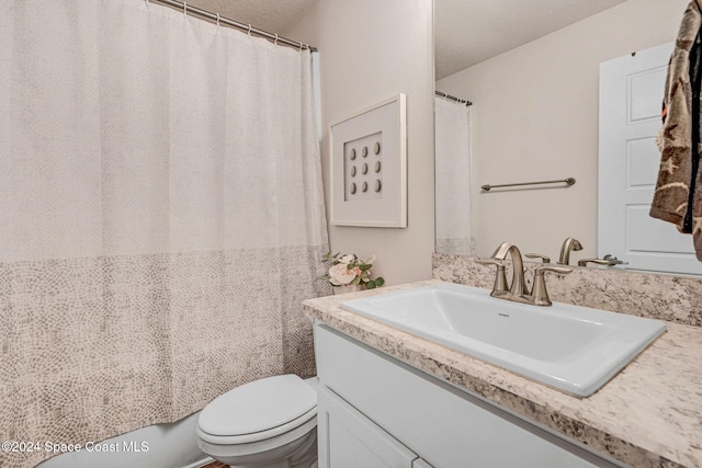 bathroom featuring vanity, a textured ceiling, and toilet