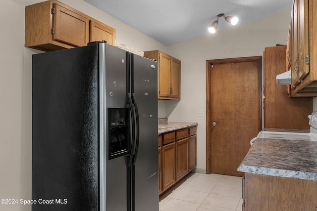 kitchen featuring a textured ceiling, stove, stainless steel refrigerator with ice dispenser, and extractor fan