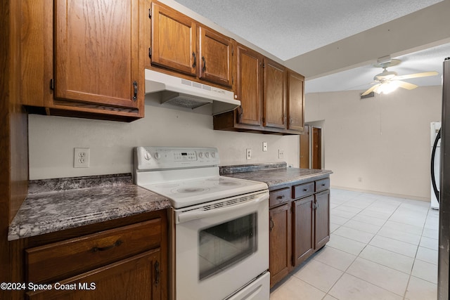 kitchen featuring a textured ceiling, vaulted ceiling, ceiling fan, white range with electric cooktop, and light tile patterned flooring