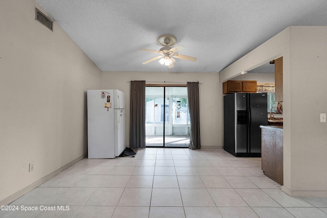 kitchen with black fridge, ceiling fan, a textured ceiling, and white refrigerator