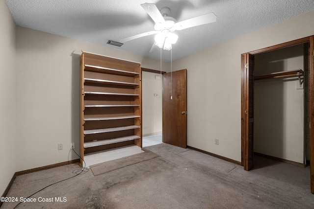 unfurnished bedroom with a textured ceiling, light colored carpet, and ceiling fan