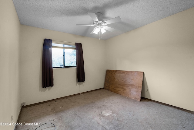 unfurnished room with ceiling fan, light colored carpet, and a textured ceiling