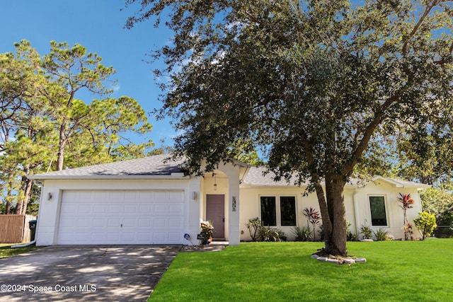 view of front of home with a front yard and a garage