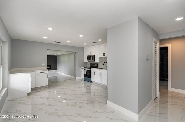 kitchen with white cabinets, sink, backsplash, and electric range