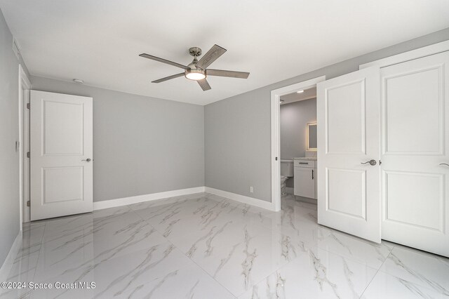 unfurnished bedroom featuring ceiling fan and connected bathroom